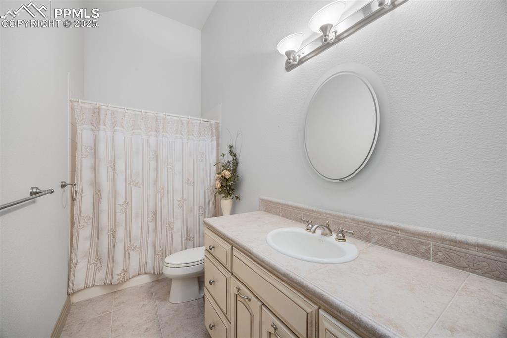 Image 41 of 41: Bathroom with vanity, curtained shower, and tile patterned floors