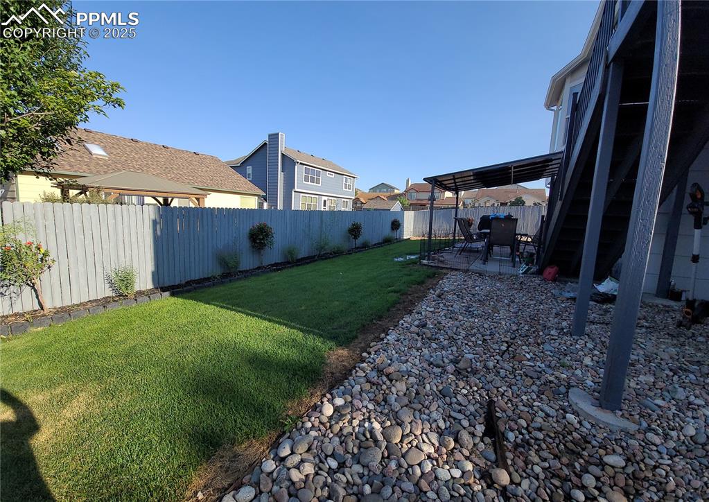 Image 3 of 11: Fenced backyard with a patio area and a residential view
