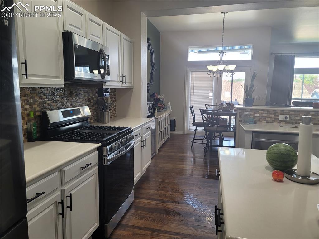 Image 5 of 11: Kitchen featuring backsplash, stainless steel appliances, light countertops