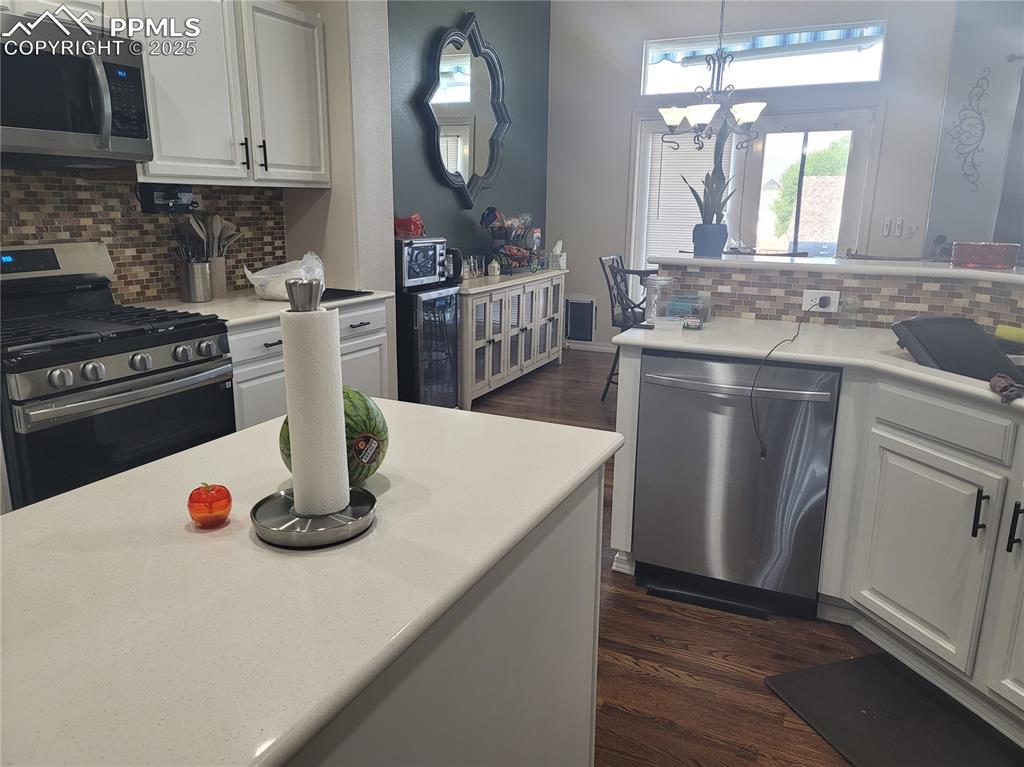 Image 9 of 11: Kitchen featuring decorative backsplash, appliances with stainless steel fi