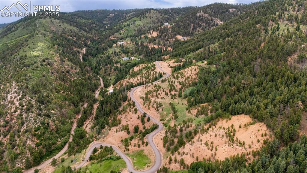 Image 17 of 21: Drone / aerial view of mountains and a heavily wooded area