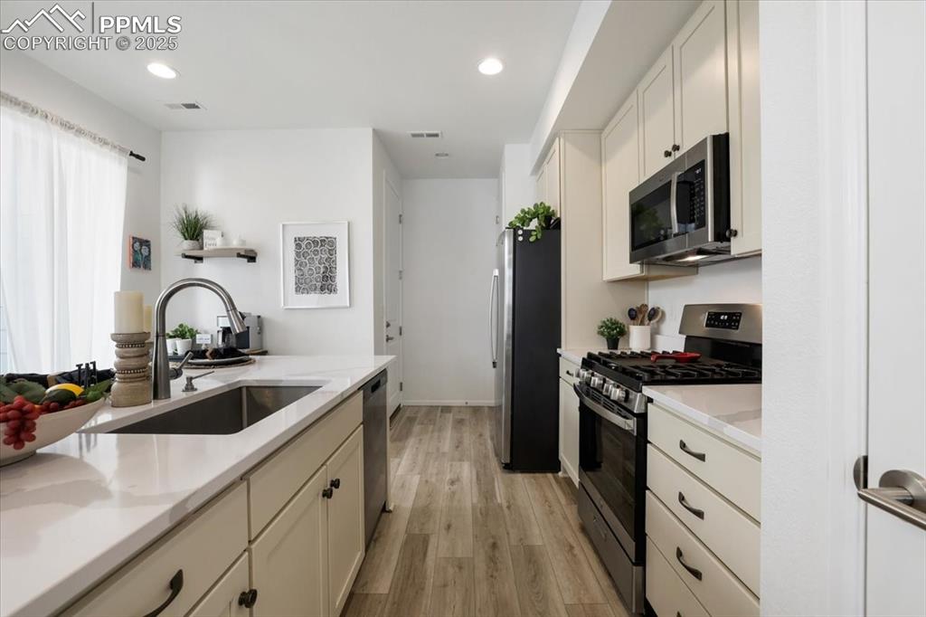 Image 14 of 28: Kitchen featuring light wood-style flooring, visible vents, stainless steel