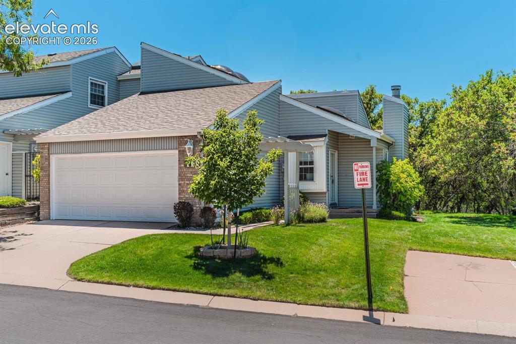 Image 1 of 36: Main level townhome featuring gray siding, a two-car garage, and a brick fa