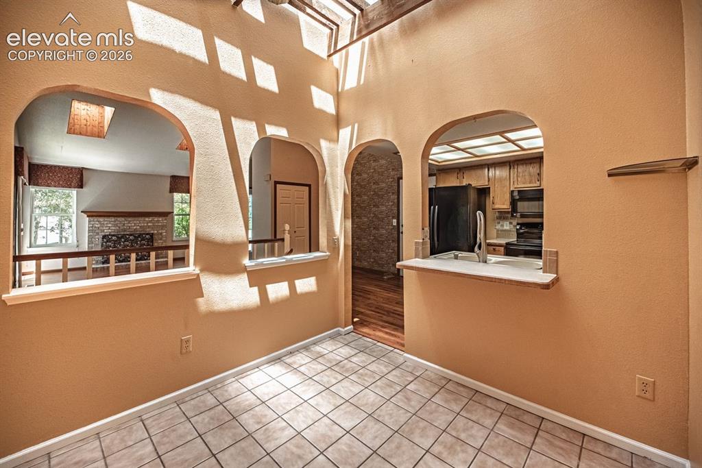Image 10 of 36: Vaulted ceiling with exposed wood beams and skylights, showcasing architect