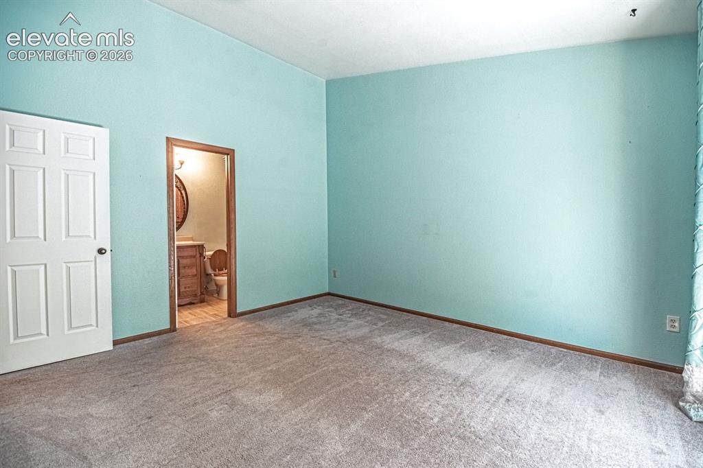 Image 15 of 36: Primary Bedroom with light blue walls and neutral carpeting, featuring an e