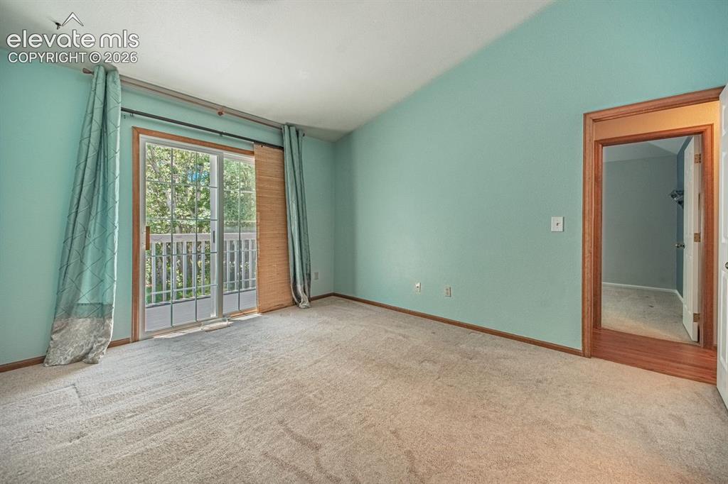 Image 18 of 36: Light-filled room featuring a sliding glass door with balcony access, warm