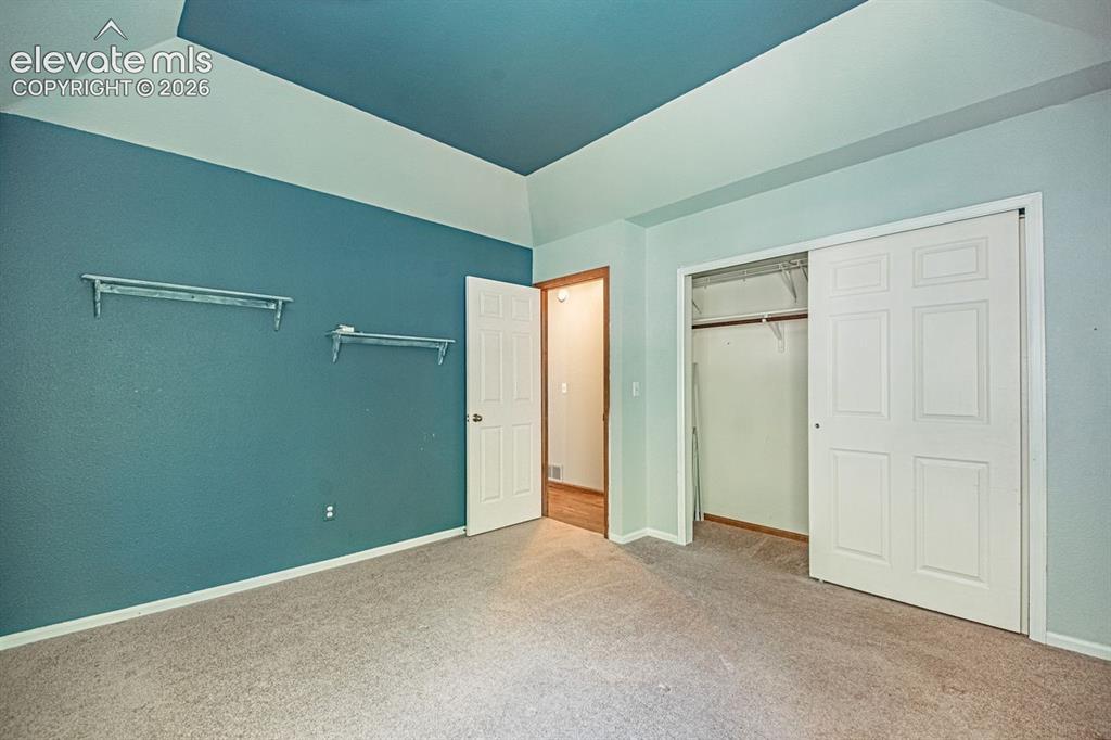 Image 26 of 36: Bedroom featuring a tray ceiling with a contrasting accent color, carpeted