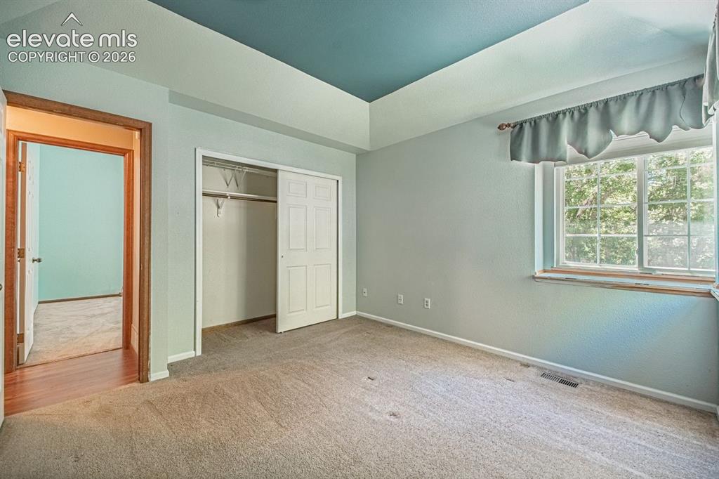 Image 28 of 36: Carpeted room featuring a tray ceiling with a contrasting painted inset