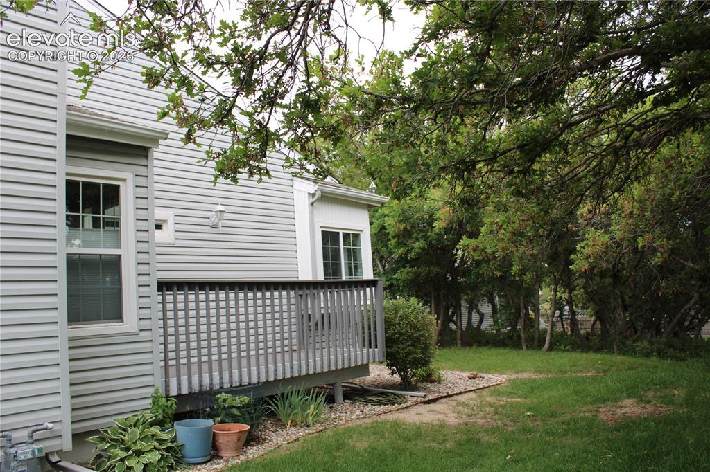 Image 32 of 36: Exterior siding in a light neutral tone featuring a private deck with dark