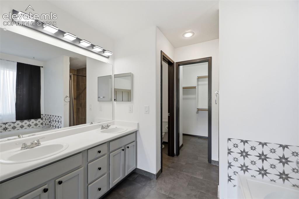 Image 18 of 48: Double vanity with undermount sinks, light gray cabinetry, and a full-width