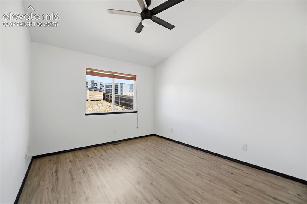 Image 21 of 48: Room with vaulted ceiling, wood-finish flooring, and a ceiling fan