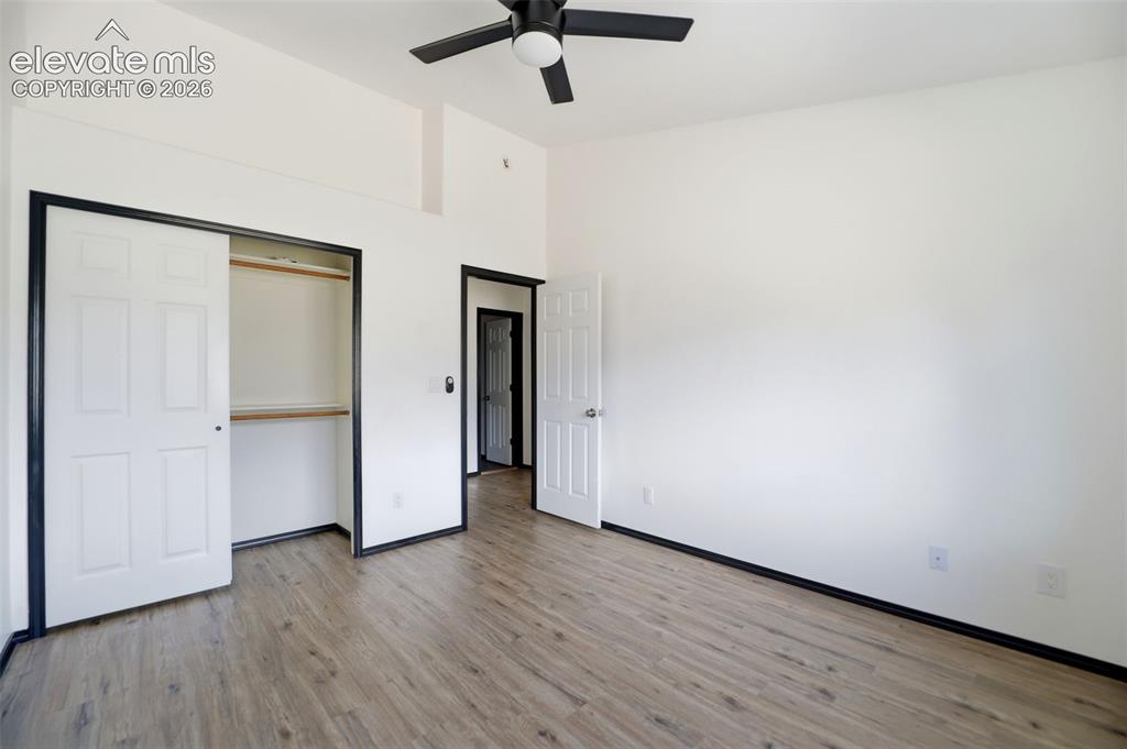 Image 23 of 48: Spacious room featuring wood-finish flooring, a built-in closet with bi-fol