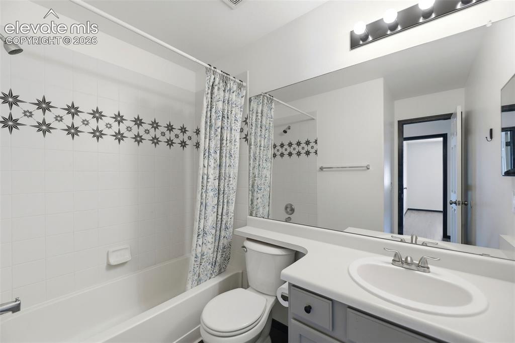 Image 24 of 48: Bathroom featuring a vanity with an integrated sink, a large wall-mounted m