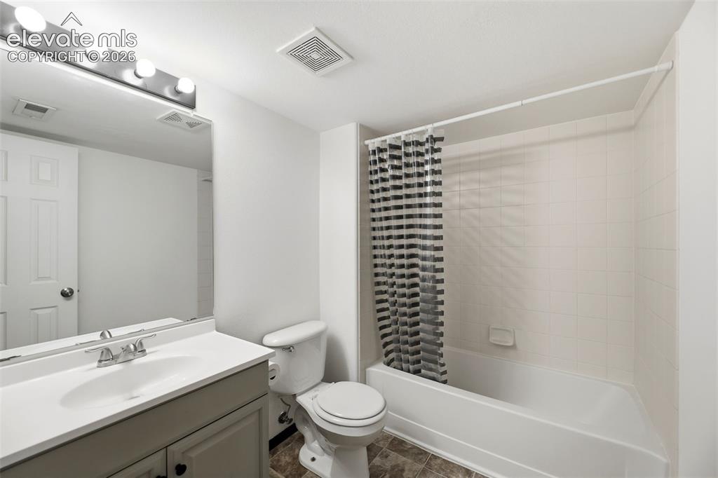 Image 29 of 48: Bathroom featuring a vanity with an integrated sink, a rectangular mirror,