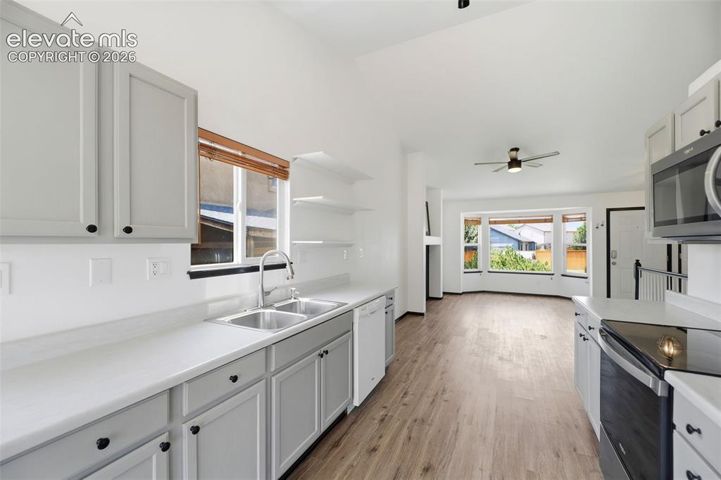 Image 3 of 48: Kitchen featuring light gray cabinetry, white countertops, dual basin stain