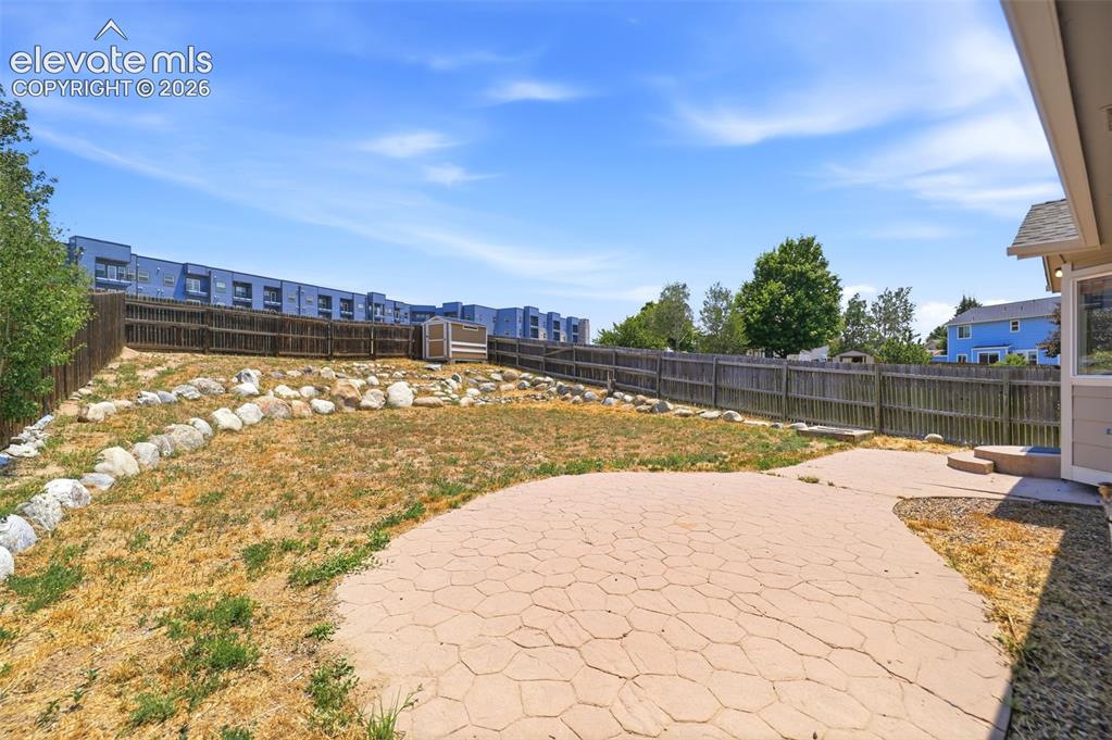 Image 41 of 48: Expansive backyard featuring a stamped concrete patio, tiered landscaping w