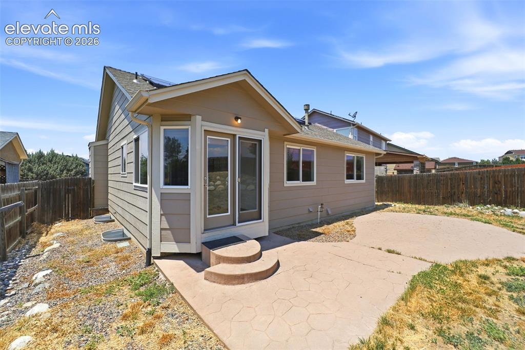 Image 46 of 48: Exterior featuring tan siding, a stamped concrete patio, and a privacy fenc