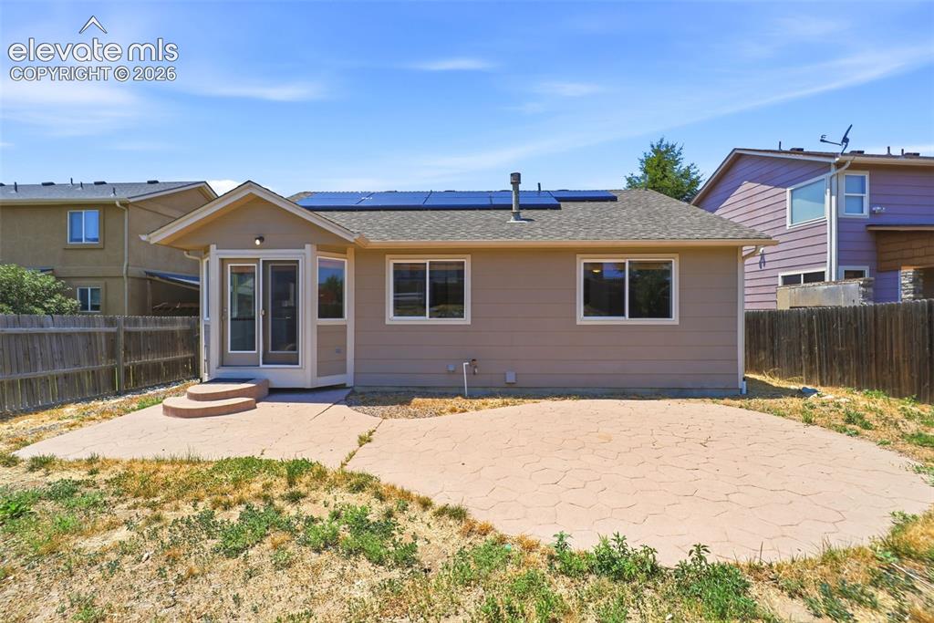 Image 47 of 48: Rear exterior featuring a stamped concrete patio, sunroom with exterior acc