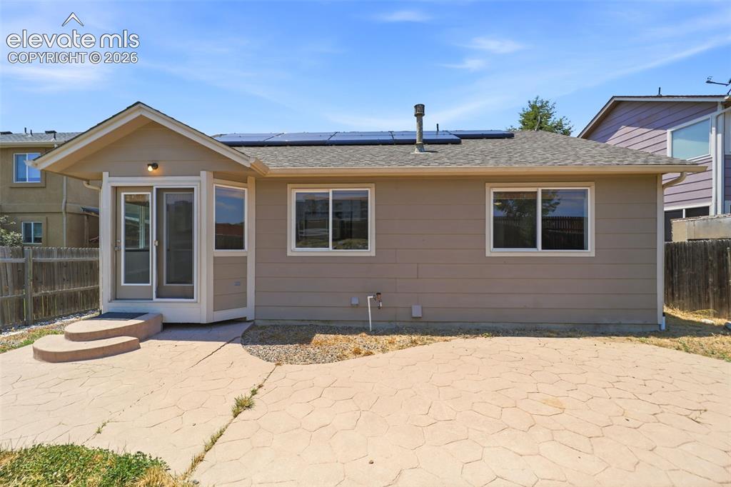 Image 48 of 48: Rear exterior featuring a stamped concrete patio, a sunroom with bay window