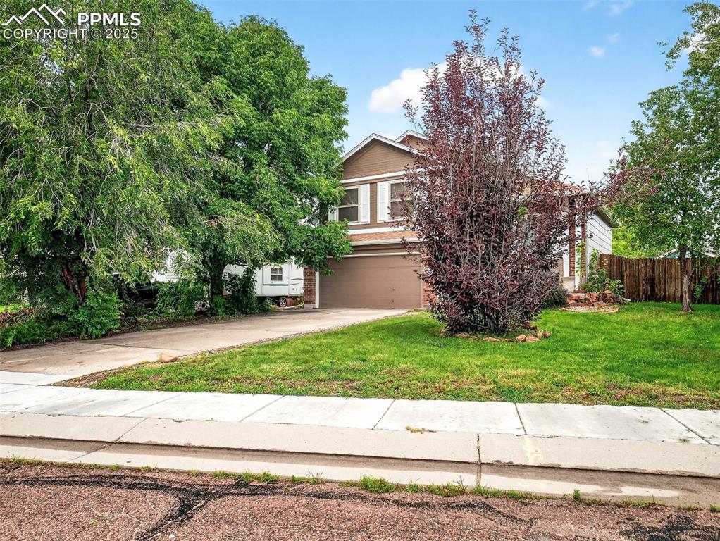 Image 2 of 26: Obstructed view of property featuring driveway, brick siding, and a garage