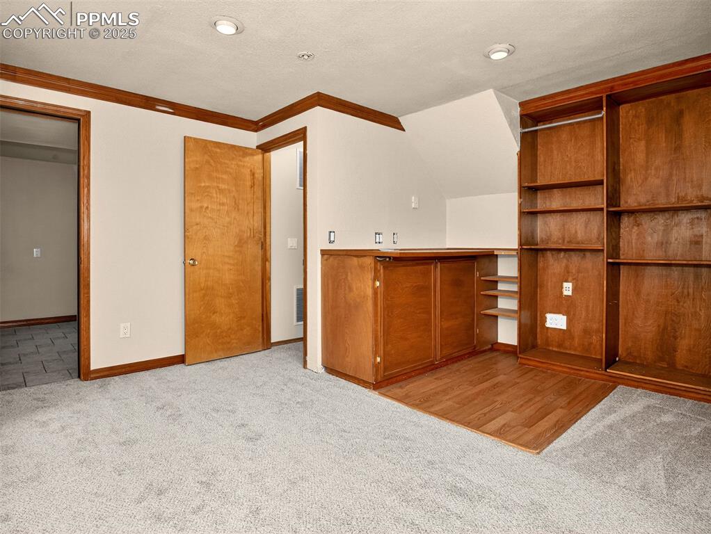 Image 22 of 26: Unfurnished bedroom with a closet, light colored carpet, ornamental molding