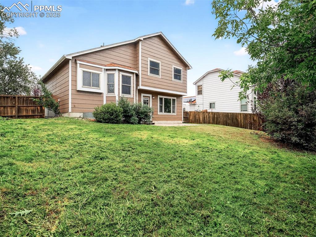 Image 26 of 26: Rear view of house featuring a fenced backyard and a patio area