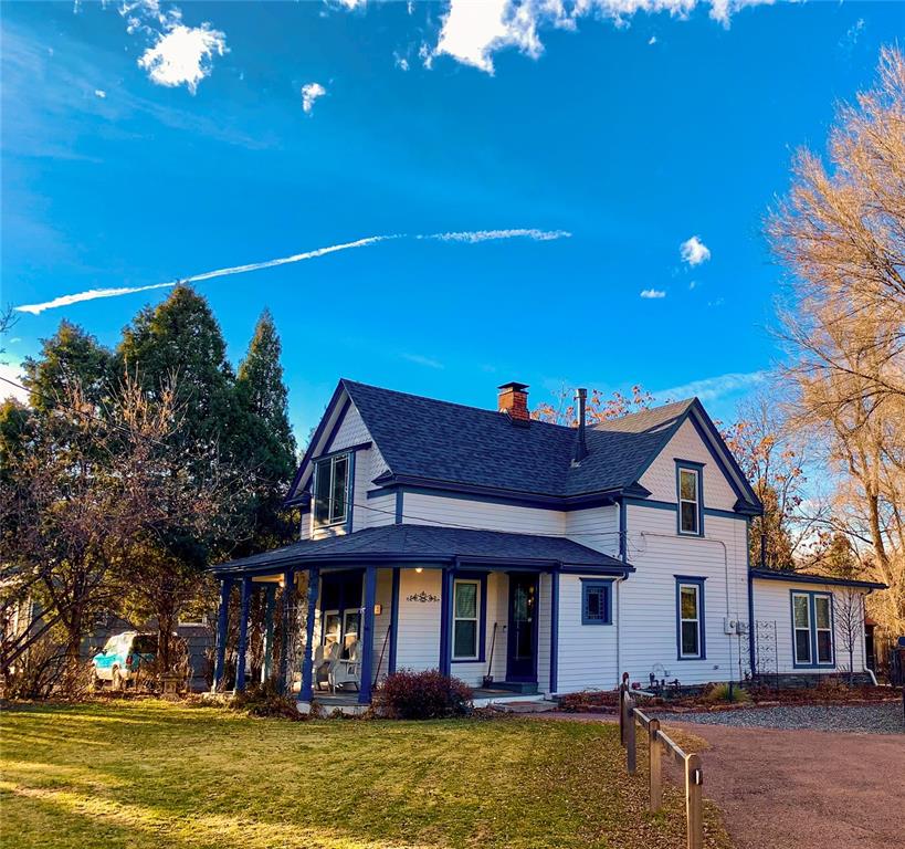 Caption: View of front of home with a porch, a front yard, and a chimney