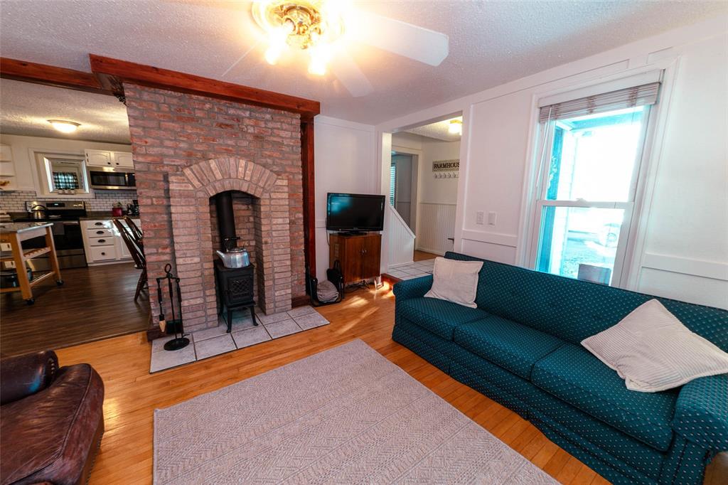 Image 32 of 46: Front room with wood burning stove