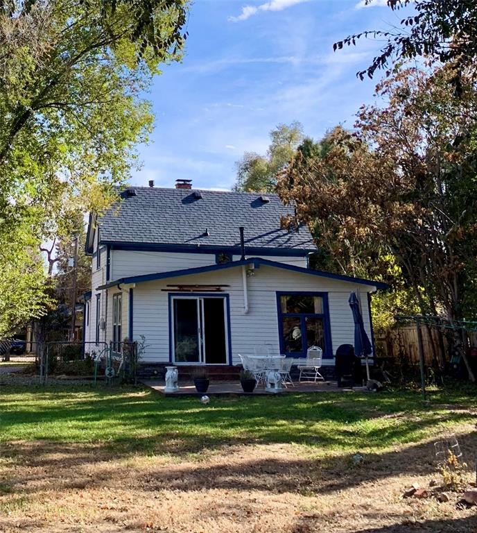 Image 45 of 46: Rear view of house with a chimney, roof with shingles, and a patio area