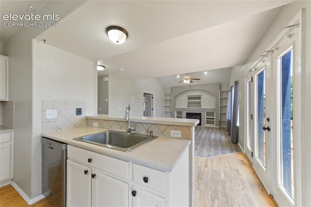 Image 10 of 36: Kitchen sink workstation featuring white cabinetry, a stainless steel sink,