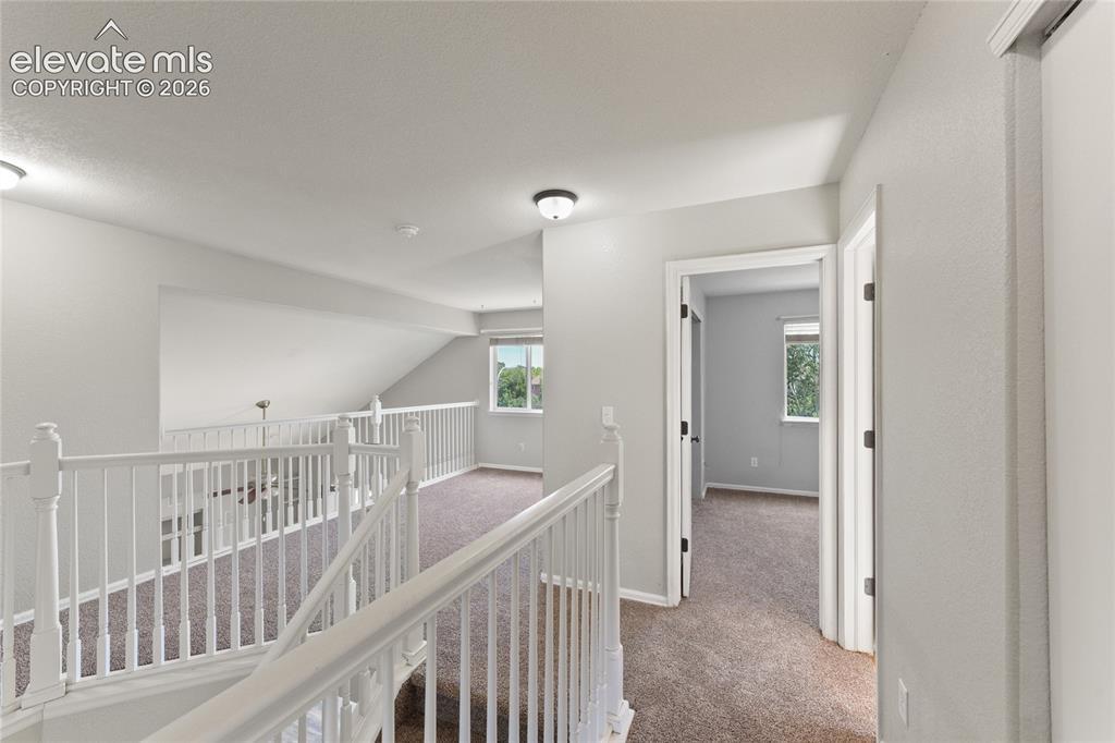 Image 17 of 36: Spacious upper-level landing featuring carpeted flooring and white painted 