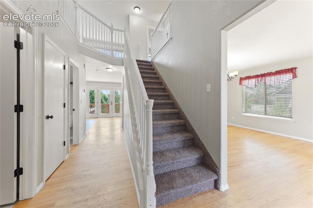 Image 2 of 36: Two-story foyer featuring wood-finish flooring, a carpeted staircase with w