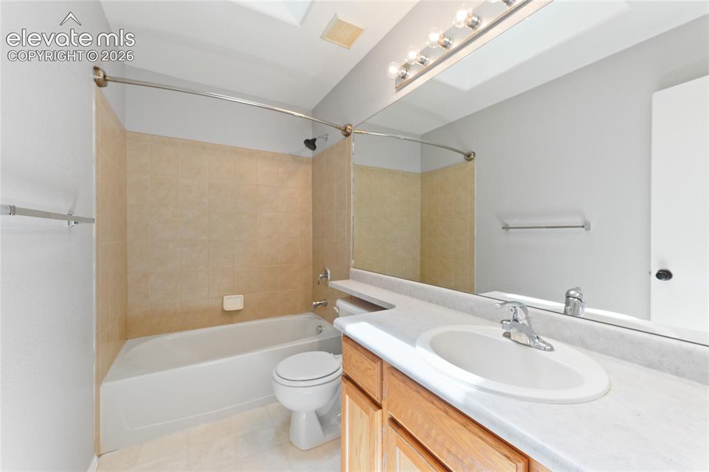 Image 28 of 36: Full bathroom featuring a single vanity with wood-finish cabinetry, a white