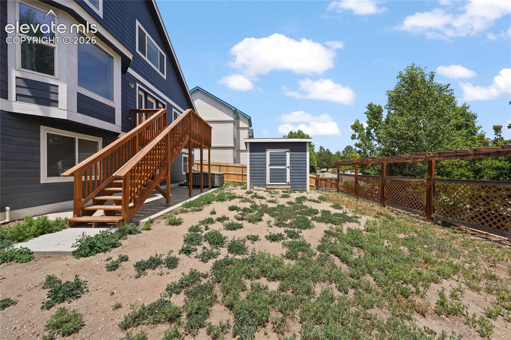 Image 33 of 36: Exterior featuring dark blue siding with white trim, a multi-level wood dec