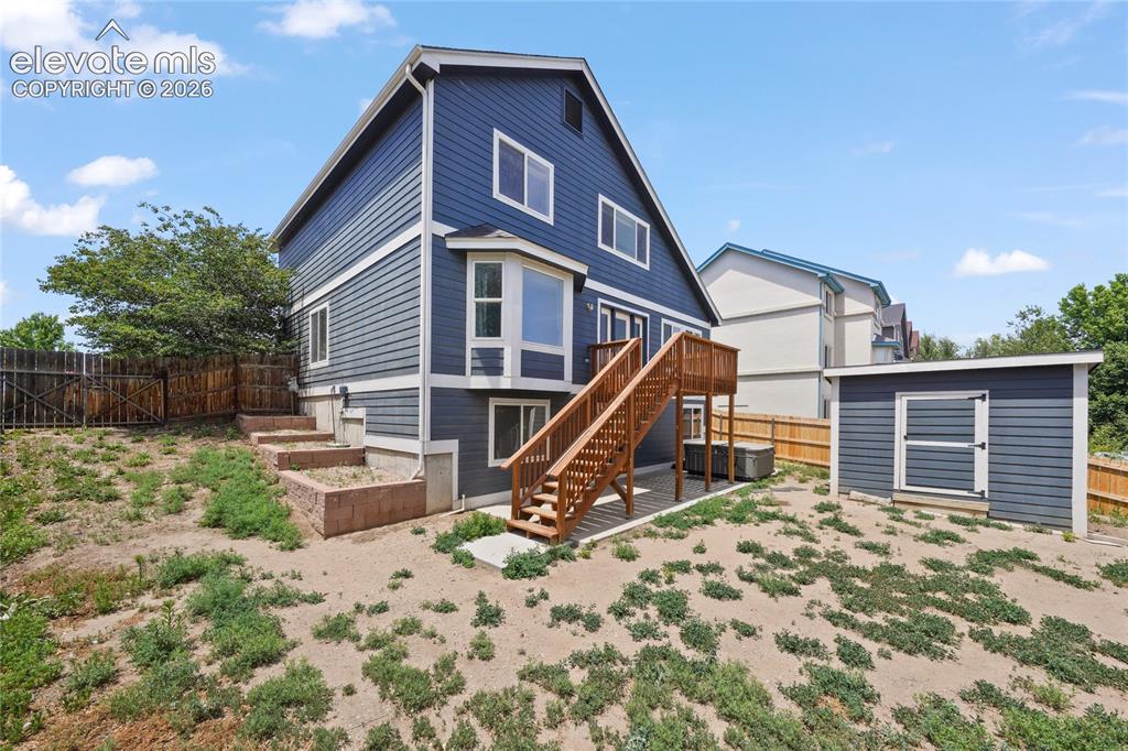 Image 36 of 36: Rear exterior featuring a blue siding facade, multi-level deck with wood st
