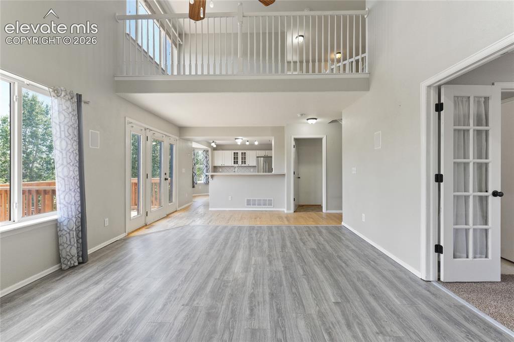 Image 7 of 36: Spacious interior featuring wood-finish flooring, a double-height ceiling, 