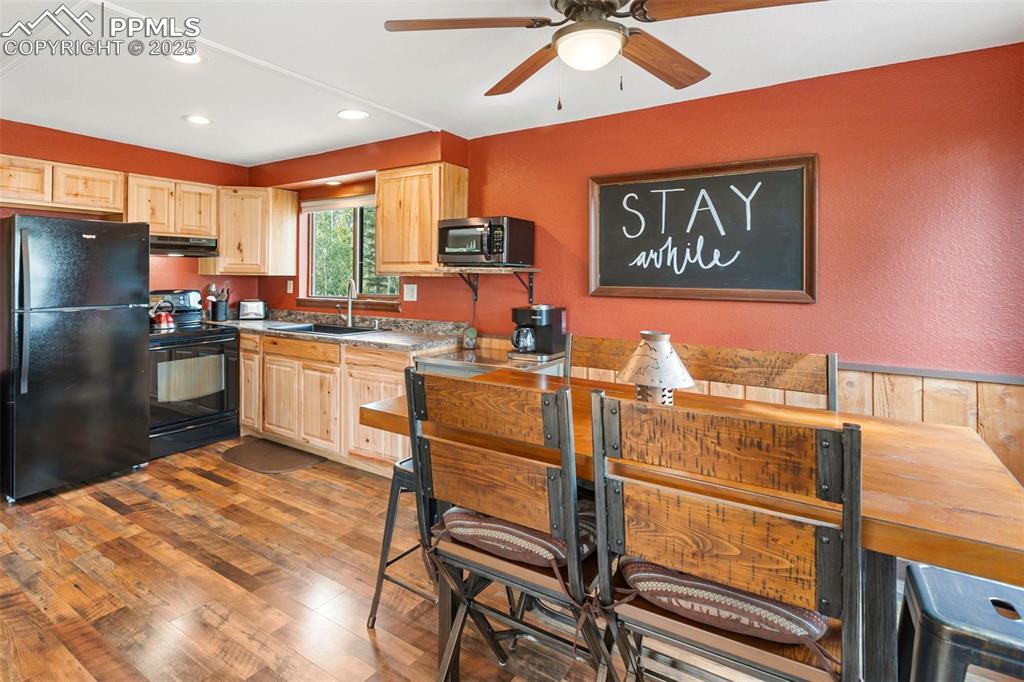 Image 11 of 50: Kitchen featuring black appliances, light brown cabinets, recessed lighting