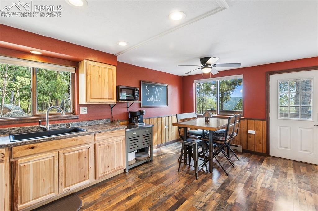 Image 13 of 50: Kitchen featuring a wainscoted wall, dark wood finished floors, healthy amo
