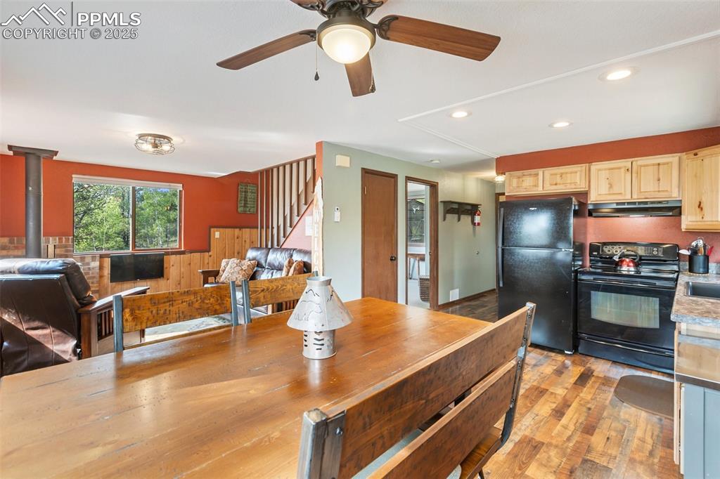 Image 14 of 50: Kitchen featuring black appliances, dark wood-style flooring, recessed ligh