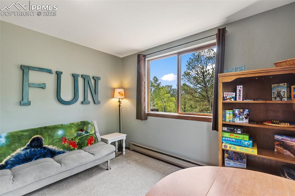 Image 18 of 50: Main level Bedroom featuring baseboard heating and carpet flooring