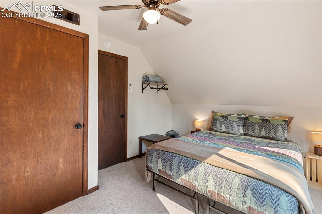 Image 24 of 50: Upper level Bedroom with lofted ceiling, carpet floors, a closet, and a cei