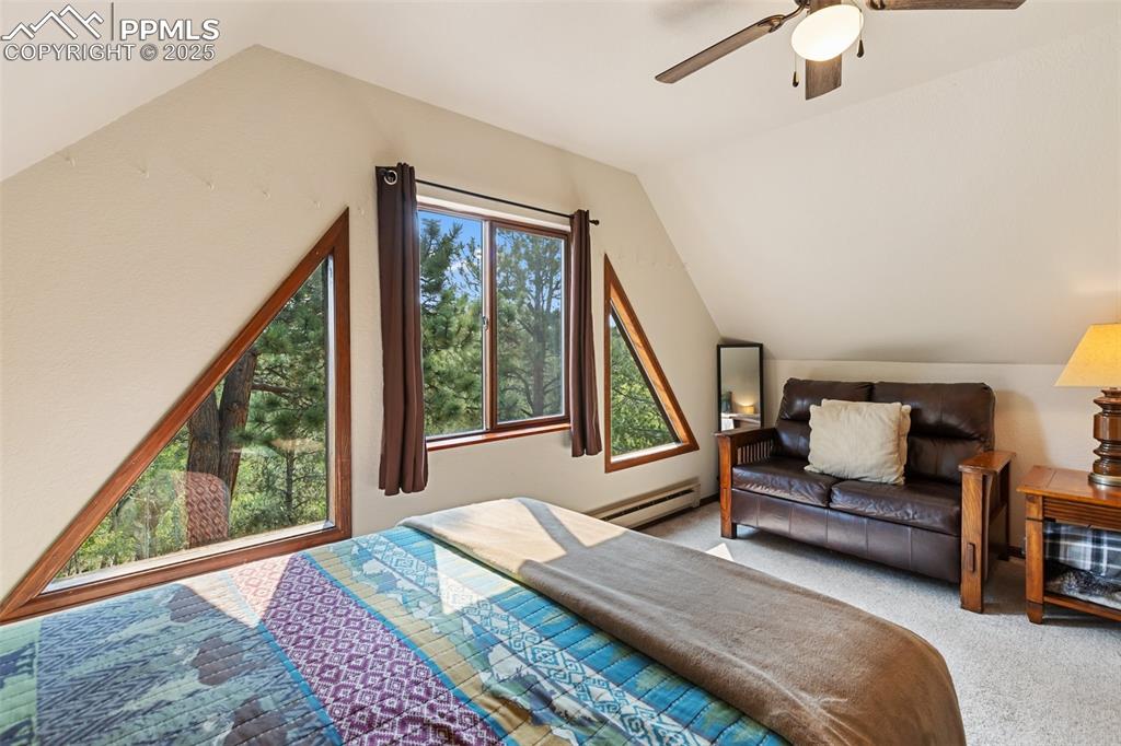 Image 27 of 50: Upper Level Bedroom featuring carpet, lofted ceiling, a baseboard radiator,