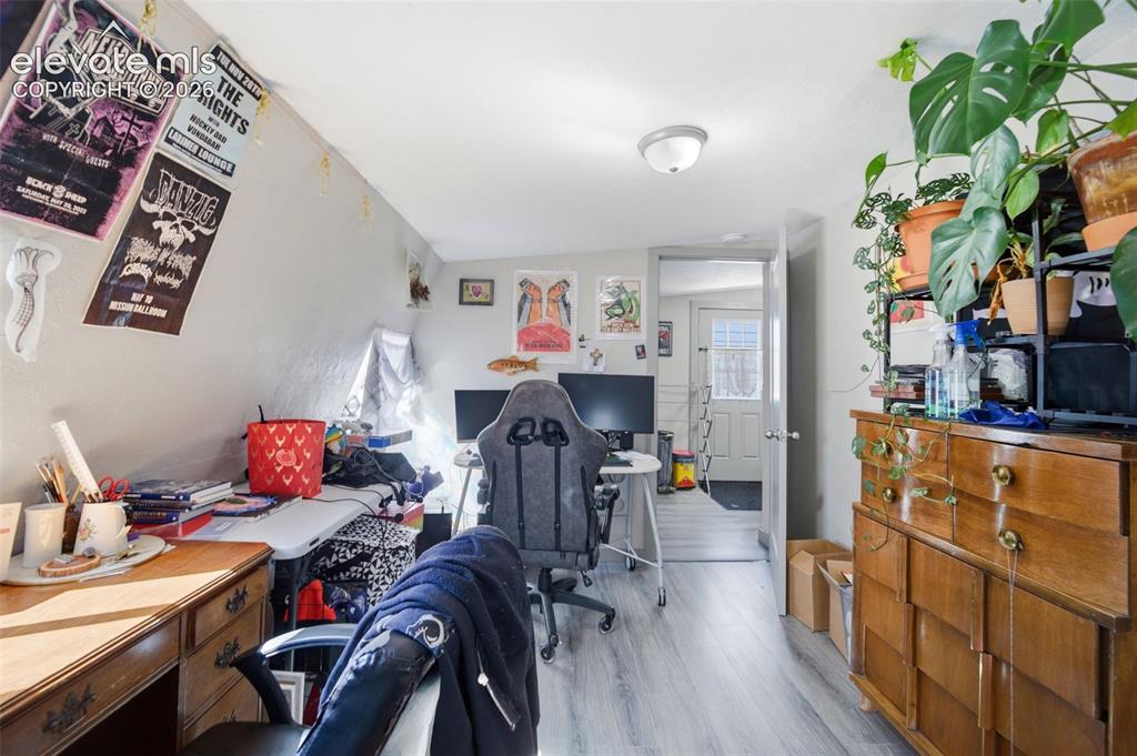 Image 11 of 30: Rear bedroom featuring sloped ceilings, a window, and wood-finish flooring
