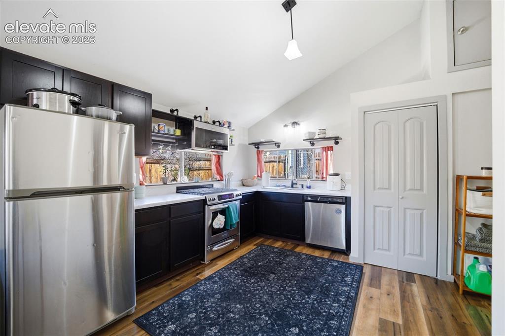 Image 17 of 30: Living area featuring vaulted ceilings, wood-finish flooring, a ceiling fan