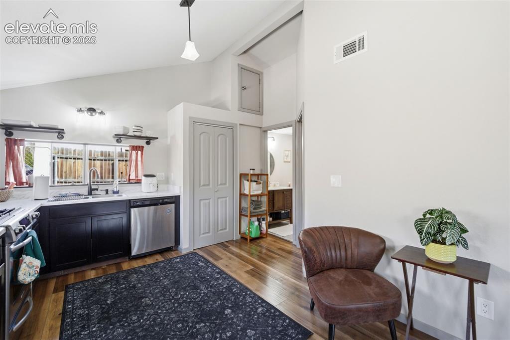 Image 20 of 30: Kitchen with dark wood cabinetry, light-toned countertops, and wood-finish