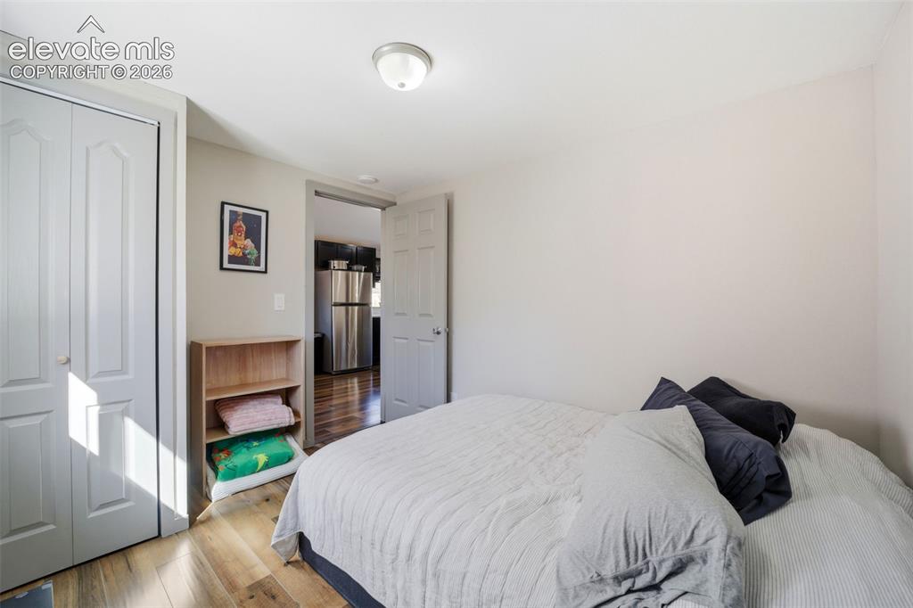 Image 22 of 30: Front bedroom featuring wood-finish flooring, white painted walls, and a si