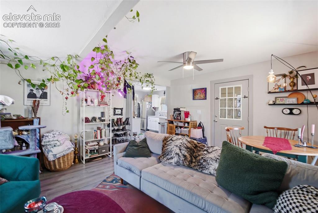 Image 4 of 30: Spacious living area featuring wood-finish flooring and ceiling fan.