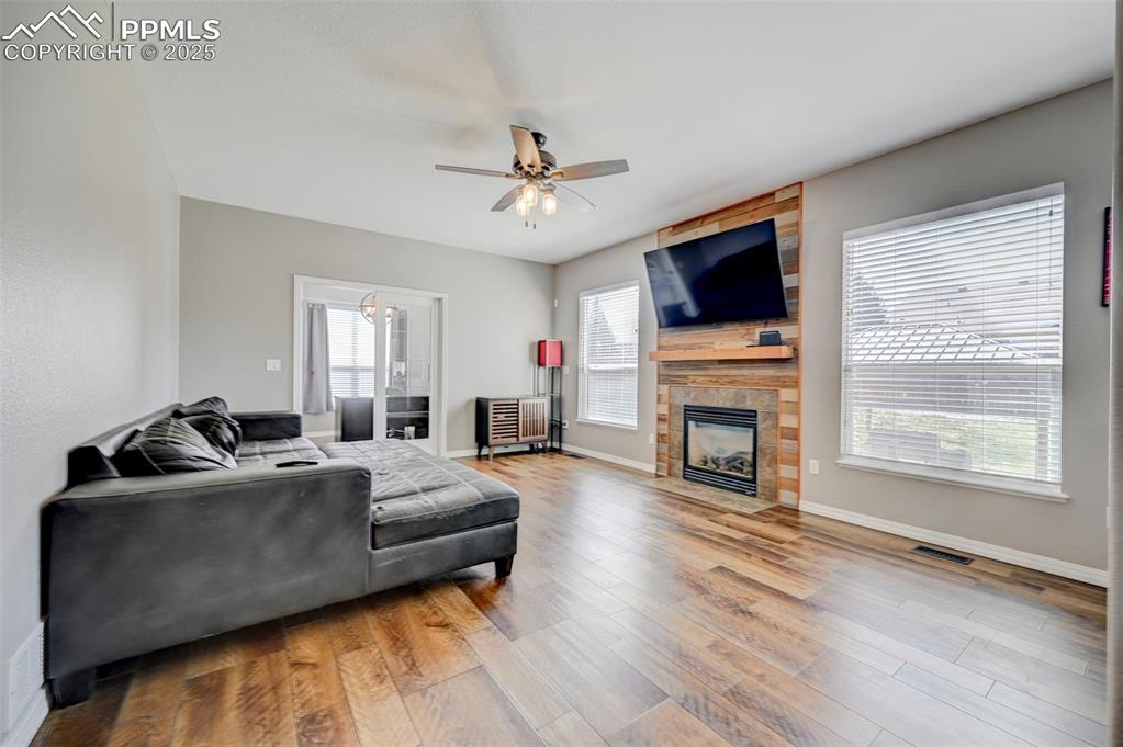 Image 10 of 31: Living area with baseboards, visible vents, wood finished floors, ceiling f