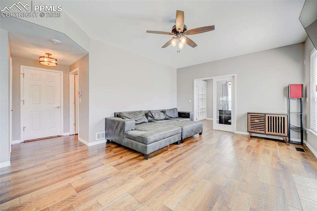 Image 11 of 31: Living area with light wood-style floors, visible vents, a ceiling fan, and