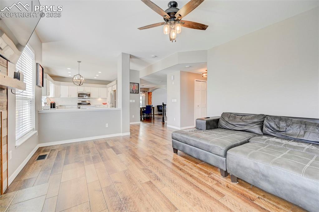 Image 12 of 31: Living room with light wood-type flooring, baseboards, recessed lighting, a